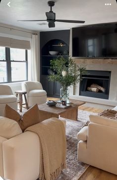 a living room filled with furniture and a flat screen tv mounted on the wall above a fireplace