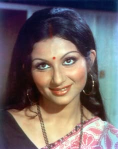 an old photo of a woman with big blue eyes and long black hair, smiling