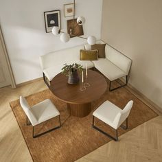 a living room filled with furniture and a rug on top of a hard wood floor