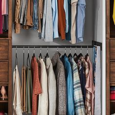 an organized closet with clothes hanging on hooks