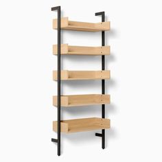 a wooden shelf with black metal brackets and shelves on each side, against a white wall