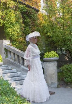 a woman wearing a white dress and hat