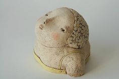 a small ceramic animal sitting on top of a white table