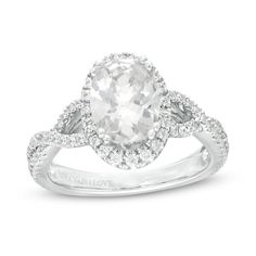 From the Vera Wang Love Collection, this diamond engagement ring is an elegant display of your affection. Fashioned in 14K white gold, this splendid look features a 2 ct. certified oval-shaped diamond boasting a color rank of I and clarity of Si2. A halo of diamonds highlights the center stone in shimmer while the twist ribbons of the split shank sparkle with diamonds. Along the gallery, a pair of princess-cut bright blue sapphires - the signature of the collection and a symbol of faithfulness a Oval Diamond Ring For Wedding And Anniversary, Oval Brilliant Cut Diamond Ring For Anniversary, Oval Brilliant Cut Diamond Anniversary Ring, Oval Diamond Ring With Brilliant Cut For Anniversary, Oval Diamond White Wedding Rings, Oval Diamond White Diamond Ring For Anniversary, Oval Diamond Ring With Center Stone For Anniversary, Oval Diamond Halo Ring For Anniversary, Oval Diamond Cut Anniversary Ring