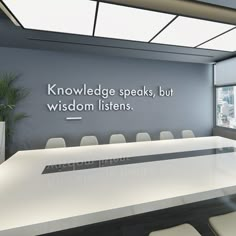 an empty conference room with white chairs and a large sign on the wall that says, knowledge speaks, but wisdom listens