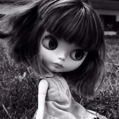 a black and white photo of a doll in the grass