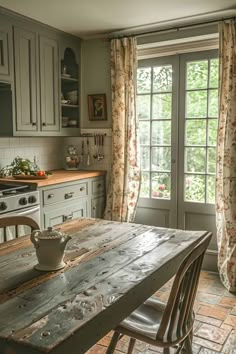 a kitchen with an old table and chairs in front of a window that has curtains on it