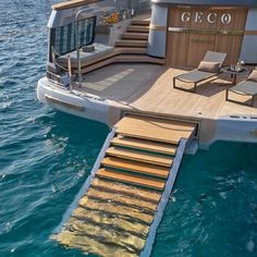 a boat with stairs going down to the deck and lounge chairs on it's side