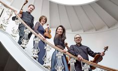 three people are standing on the stairs with their instruments in hand and one person is holding a violin