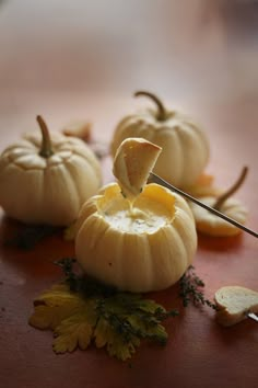 small white pumpkins sitting on top of a table