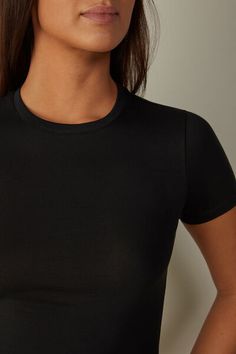 Short sleeve top with round neckline in stretch Superior cotton. A simple and cozy top, ideal to wear on any occasion, either as an undergarment or on its own for a casual look. Sleek Crew Neck Top With Minimal Stretch, Elegant Seamless Crew Neck Tops, Seamless Crew Neck Elastane T-shirt, Seamless Elastane Crew Neck T-shirt, Seamless Short Sleeve Tops For Layering, Seamless Crew Neck T-shirt With Comfort Fit, Chic Crew Neck Tops With Minimal Stretch, Elegant Crew Neck Top With Minimal Stretch, Seamless Scoop Neck T-shirt For Loungewear