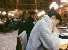 a woman sitting at a table in a library