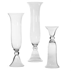 three tall glass vases sitting next to each other on a white background, one is empty