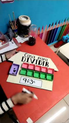 a child is playing with some colored blocks on the table in front of their desk