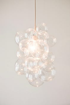 a chandelier hanging from a ceiling in a room with white walls and flooring