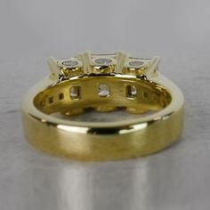 a yellow gold wedding ring with three diamonds