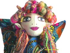 a stuffed doll with colorful hair and beads on it's head, sitting in front of a white background