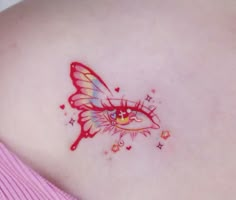 a woman's breast with a butterfly tattoo on her left shoulder and stars around it