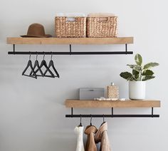 two shelves with hats, sweaters and other items on them next to a potted plant