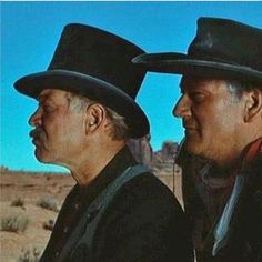 two men in black hats standing next to each other