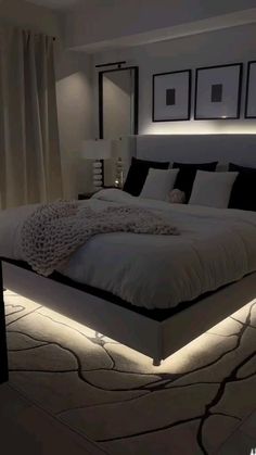 a large bed sitting in the middle of a bedroom next to two lamps on either side of it