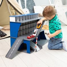 a young boy playing with a toy car set