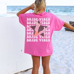 Get ready to fall in LOVE with your new Bride Vibes aesthetic t-shirt. The shirt features a back print design and a star cowgirl boot print in the front pocket area.  It's the cutest and most comfortable way to wear the latest styles. Looking for a 'Babe Vibes' shirt as well? Check out our listing here: https://www.etsy.com/ShopForeverFriday/listing/1454501155/coastal-cowgirl-bachelorette-shirt-bride * PRODUCT DETAILS * ✺ 100% Cotton ✺ Medium weight fabric  ✺ Wash and dry normally (on cool for b Pink Summer T-shirt For Day Out, Trendy Pink T-shirt For The Beach, Vacation Short Sleeve T-shirt For Day Out, Summer Printed Pink Camp Shirt, Summer Pink Printed Camp Shirt, Pink Short Sleeve T-shirt For The Beach, Pink Short Sleeve Beachy T-shirt, Pink Short Sleeve T-shirt For Summer, Summer Pink Shirt With Screen Print