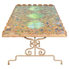 an ornately designed metal table with green and blue tiles on it's top