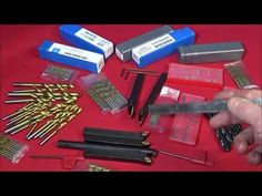 there are many different types of screws and tools on the red tablecloth,