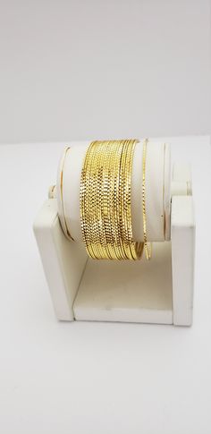 "* Handcrafted Gold Plated Bangle Set * High Quality 22 K Gold Plated 24 pc. Bangle set * Size: 2.2 has 2.2\" inner circle diameter ; 2.4 ( 2.31\" inner circle diameter) ; 2.6 ( 2.46\" inner circle diameter); 2.8 (2.64\" inner circle diameter) * Sold as a set of 24 bangles Gorgeous gold-plated bangle/ bracelet best exemplifies the careful craftsmanship done on it -- a specialty at Nemali Jewelry. It has a special tone of elegance attached to it. The intricate handmade design of the bangle / brac Indian Wedding Bangles, Wedding Bangles, Kundan Bangles, Indian Bangles, Glass Bangles, Bangles Set, Gold Plated Bangles, Bangle Bracelet Set, Bangles Indian