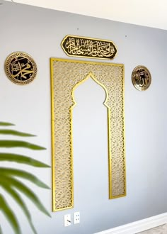 the wall is decorated with arabic calligraphy and gold decorations, along with a potted plant