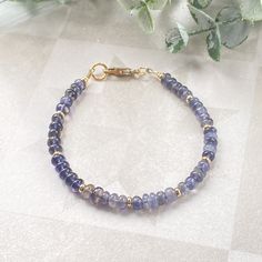 This juicy gemstone beaded bracelet is full of color!  The bracelet band is made of the most beautiful purpley- blue 4mm iolite rondelle beads.  Every fifth rondelle bead is accented with a 14k gold filled heishi bead.  A simple 14k gold filled minimalist lobster claw finishes off this bracelet.  This sweet, delicate bracelet is bursting with color and would look amazing alone on your wrist or paired with friends for your own unique stack.  It can also make a very thoughtful gift for friends and Perle Heishi, Purple Beaded Jewelry, Beaded Jewelry Earrings, Handmade Boho Jewelry, Bleu Violet, Jewelry Dainty, Boho Luxe, Gemstone Beaded Bracelets, Minimalist Bracelet