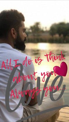 a man with a beard sitting on a dock looking at the water and holding a heart