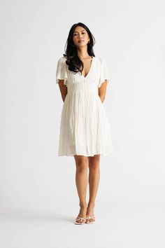 "The Sun Is Out And It'S Time To Have Some Fun! Throw On Our Out Of Time Cream V-Neck Pintuck Pleated Dress And Head Out The Door. This Skater Dress Is Perfect For A Day Of Exploring. With A Pleated Skirt And V Neckline, This Dress Is Both Flattering And Comfortable. The Short Sleeves And Flowy Silhouette Make It Perfect For A Hot Summer Day. Whether You'Re Headed To The Beach Or The Park, This Dress Is Sure To Keep You Feeling Cool And Looking Cute." Summer V-neck Mini Dress With Pleated Waist, White Pleated Summer Dress, Pleated V-neck Sundress, Breezy V-neck Sundress For Daywear, Flowy A-line Pleated Dress For Summer, Summer Mini Dress With Pleated Waist For Day Out, Summer Mini Dress With Pleated Waist, Pleated Mini Sundress, Pleated Mini Length Sundress