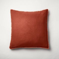 an orange pillow on a white wall