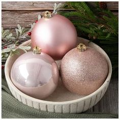 three ornaments in a bowl on a table