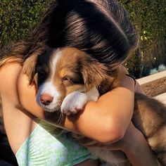 a woman holding a puppy in her arms