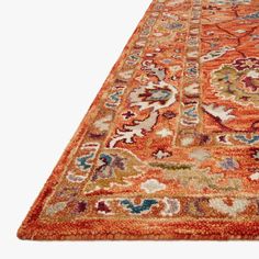 an orange rug with many different colors and designs on the carpet is shown in front of a white background