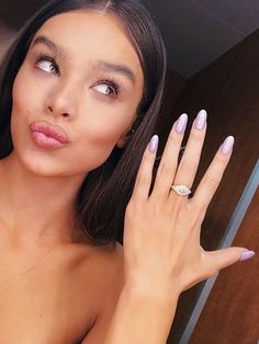 a woman with long nails and a ring on her finger is posing for the camera