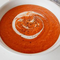 a bowl of tomato soup with cream in it