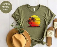 "Retro Tropical Sunset Summer Shirt, Summer Vibes Tshirt, Palm Beach Shirt, Beach Trip Gifts, Funny Summer Camp Tee, Cute Unisex Graphic Tee Please Check All Photos For Details.   🐞Choose Your T-Shirt Size From The Drop-Down Lists Next To The item Picture   ⭐Choose Of Your T-Shirt Color From The 2nd Picture   🐞Use \"Add message to Seller\" link On The Checkout Page To Send me the Following important Details For Your Order's Customization.   ⭐Shipping Time Varies by location (we are located in Sugar Land, Texas) please consider that our turn around time is 1 to 3 business days.     ⭐Which brand do you use for t-shirts? We use Gildan Softstyle, Bella Canvas Unisex, Hanes, Outlash, Tees,  District and Next Level when we have a shortage of stocks for certain colors and sizes. Our printing me Casual T-shirt For Outdoor Summer Activities, Casual Summer T-shirt For Outdoor, Summer Outdoor Cotton T-shirt, Short Sleeve T-shirt For Summer Outdoor, Summer Graphic Print Tops For Outdoor, Green Palm Tree Print Camp Shirt For Beach, Green Summer Beach Shirt, Casual Beach Season Tops For Outdoor, Casual Tops For Beach Season