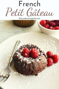 a chocolate cake with raspberries on top and the words french petit gateau above it