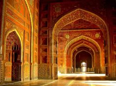 the inside of an ornate building with many arches and doorways on either side of it