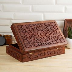 a wooden box sitting on top of a table next to a potted plant and other items