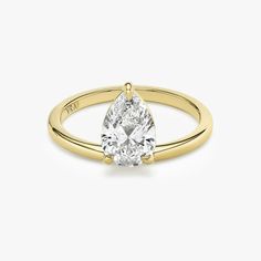 a yellow gold engagement ring with a pear shaped diamond in the center, on a white background