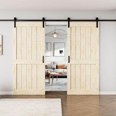 an open sliding door in a living room with hardwood floors and white walls, along with a rug on the floor