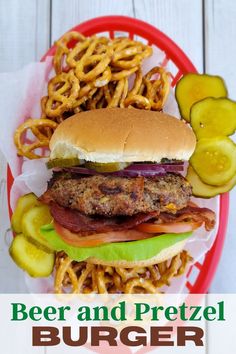 a burger with onion rings and pickles on the side