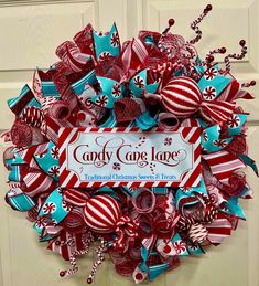 a wreath with candy canes on it is hanging on the front door for someone to decorate