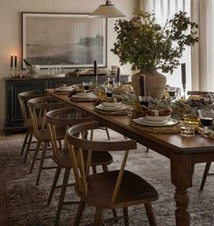 a dining room table is set with plates and place settings