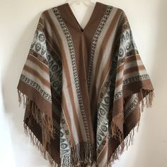 "This is a traditional heavy weight Andean poncho made by one of our most talented weavers. The natural fiber yarn is hand-dyed and woven into beautiful patterns and color arrangements. Perfect to keep you warm around ceremonial fires! There is yarn fringe at the bottom.  One size fits most adults. Unisex. Dimensions: 66\" x 44\" Peruvian woven textiles are incomparable in their quality and beauty. Add this to your collection today! We are a non-profit organization and proceeds from all sales go Traditional Handwoven Poncho For Fall, Bohemian Alpaca Shawl One Size, Bohemian Alpaca Shawl, Artisan Poncho For Fall, Artisan Handwoven Poncho, One Size, Handwoven Poncho Shawl For Festivals, Artisan Poncho For Fall One Size, Handwoven Festival Poncho Shawl, Bohemian Alpaca Shawl Cape